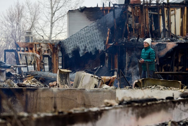 Woman surveying wildfire damaged property